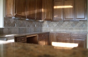 Granite tile countertops with travertine backsplash