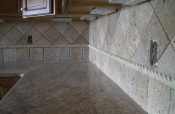 Granite tile countertops with travertine backsplash