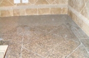 Granite tile countertops with travertine backsplash
