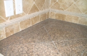 Granite tile countertops with travertine backsplash
