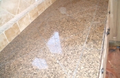Granite tile countertops with travertine backsplash