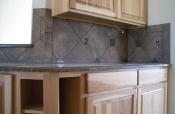 Porcelain backsplash with granite inserts and countertops