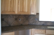 Porcelain backsplash with granite inserts and countertops