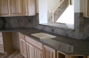 Porcelain backsplash with granite inserts and countertops