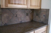 Porcelain backsplash with granite inserts and countertops