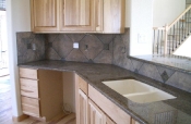 Porcelain backsplash with granite inserts and countertops