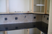 Porcelain kitchen backsplash with slate inserts and granite countertops