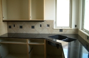 Porcelain kitchen backsplash with slate inserts and granite countertops