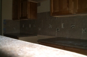 Porcelain backsplash with glass and travertine inserts