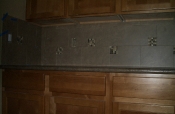 Porcelain backsplash with glass and travertine inserts