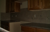 Porcelain backsplash with glass and travertine inserts