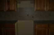 Porcelain backsplash with travertine and glass inserts