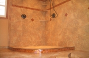 Porcelain shower with glass accents and curved glass curb