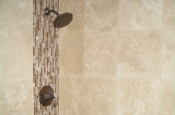 Travertine and glass master bathroom shower tile with oil-rubbed bronze installation in Fort Collins, Colorado
