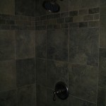 Slate-like porcelain kerdi shower with oil-rubbed bronze fixtures