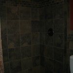Slate-like porcelain kerdi shower with oil-rubbed bronze fixtures